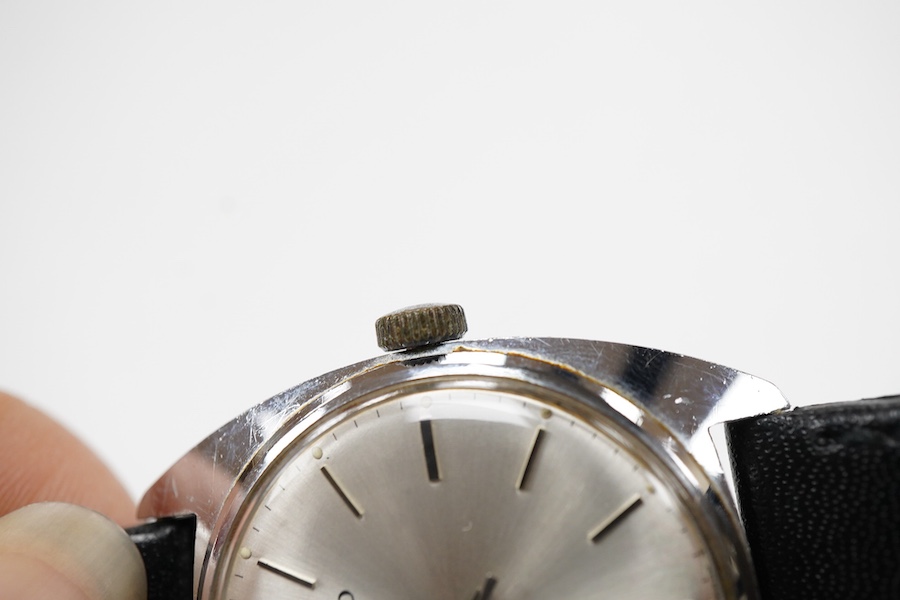 A gentleman's stainless steel manual wind wrist watch, retailed by Garrard, with baton numerals, case diameter 33mm, on a black leather strap.